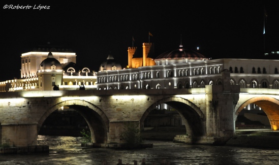 Instantánea nocturna con el puente de piedra, el Teatro Nacional y la fortaleza de Skopje